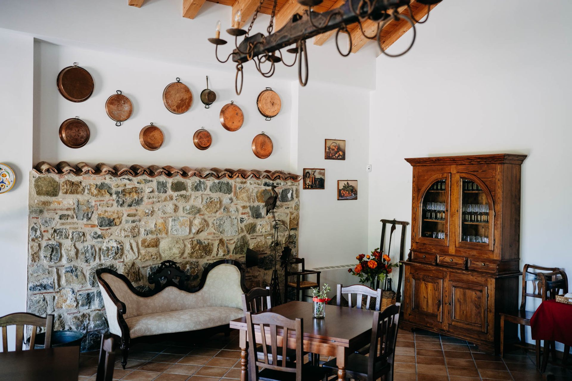 Salotto interno con divano d'epoca e parete in pietra