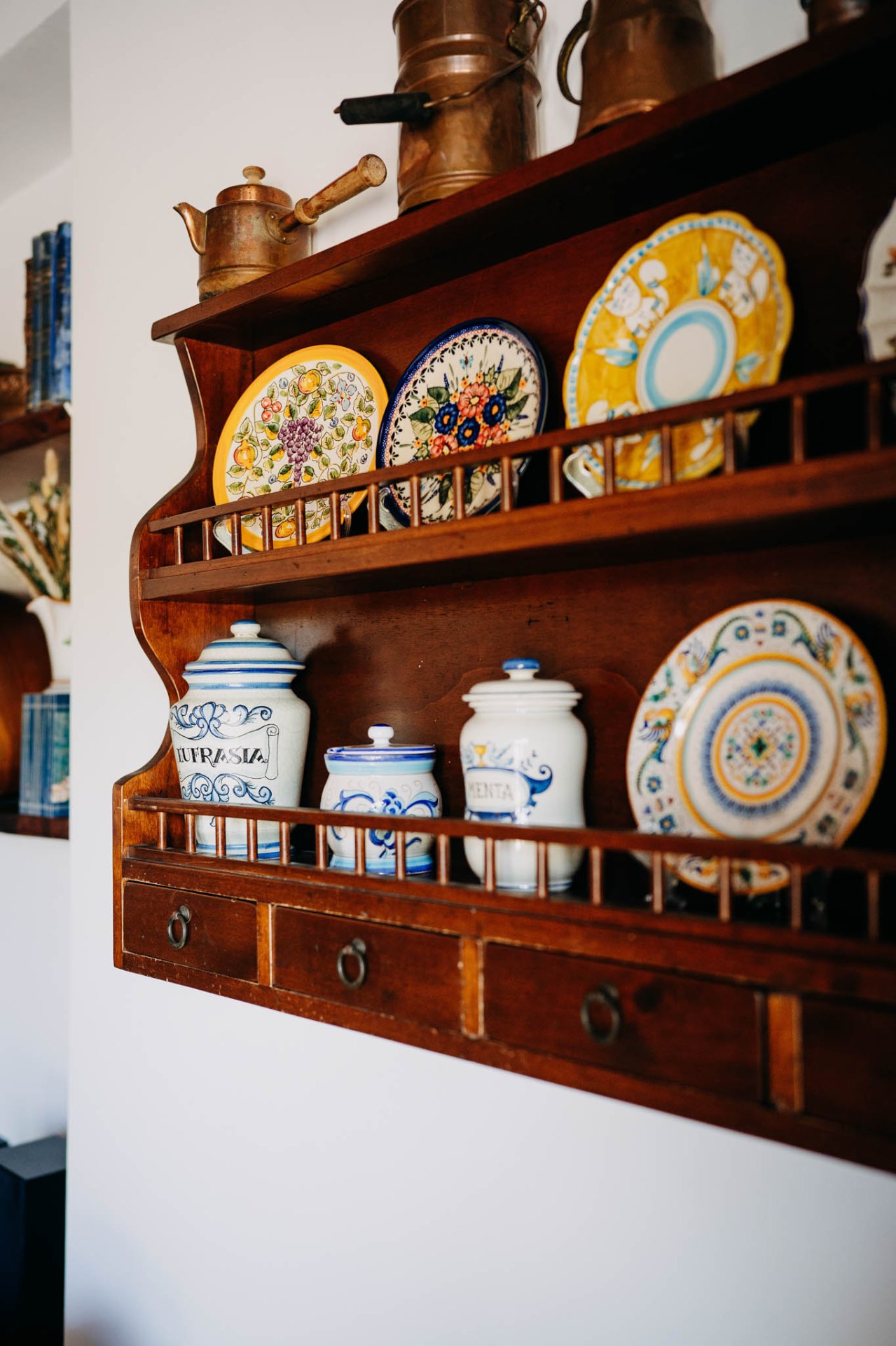 Credenza in legno con piatti decorativi e ceramiche dipinte