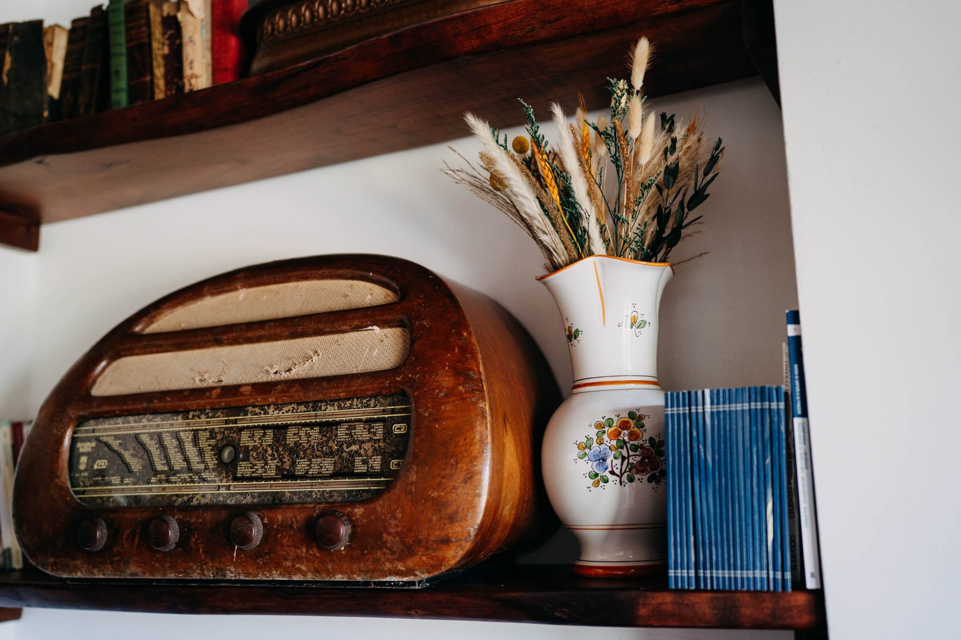 Radio d'epoca e vaso decorato su mensola in legno